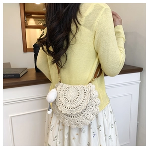 Detail of crochet saddle bag with ivory shell patterns and a brown leather strap