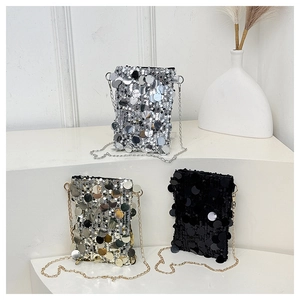 Three sequin crossbody bags in silver, gold, and black with metal chains on a display