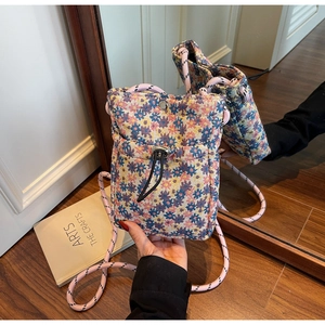 Detailed macro of floral pattern crossbody phone bag with woven drawstring shoulder strap
