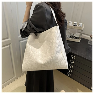 Détail du grand sac cabas blanc crème à motif crocodile avec large bandoulière sur modèle