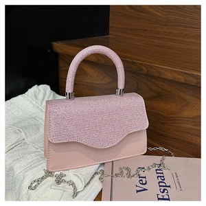 Détail du sac de soirée rose brillant avec strass et fine bandoulière en chaîne