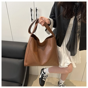 Sac cabas en cuir tressé marron porté par un mannequin montrant la grande capacité