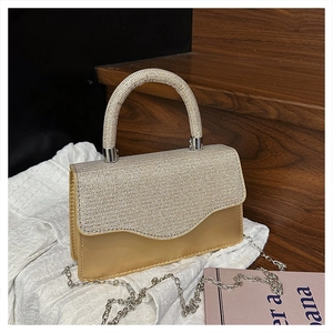 Détail du rabat pailleté argenté et du sac de soirée carré en cuir beige avec chaîne