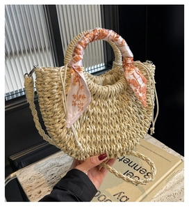 Detail of woven crescent bag featuring a silk scarf handle and drawstring closure