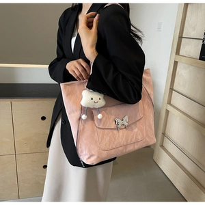 Detailed shot of pink tote bag featuring a silver butterfly buckle and cloud charm accessory