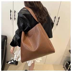 Vue détaillée d'un grand sac cabas marron à motif crocodile porté à l'épaule