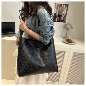 Détail d'un grand sac fourre-tout noir avec une finition texturée en faux serpent
