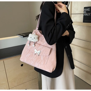 Pink tote bag detail with silver butterfly buckle and cute plush cloud keychain charm