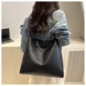 Détail d'un grand sac fourre-tout noir avec texture tressée pour le trajet quotidien