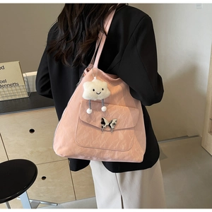 Close-up of pink tote bag with silver butterfly buckle and white plush cloud pendant