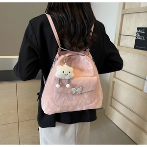 Detail of pink pleated tote bag with metal butterfly buckle and plush cloud charm