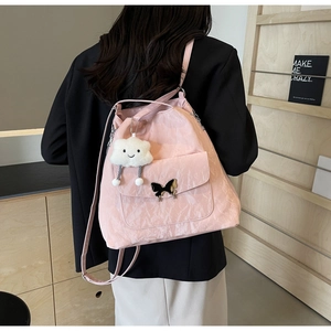 Pink pleated nylon backpack featuring a metal butterfly and a white cloud plush charm