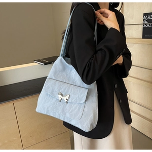 Detail of light blue pleated tote bag featuring a silver butterfly buckle and large capacity