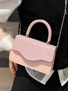 Sac à main élégant rose avec strass et bandoulière chaîne porté par un modèle