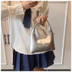 Silver metallic hobo bag detail held by model in minimalist modern industrial style
