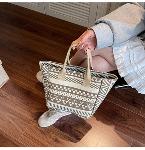 Close-up of geometric striped canvas tote bag with woven textures and beige brown tones