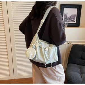 Detail of mint green ruched drawstring tote bag with detachable round coin purse and strap