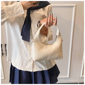 Detailed view of a white glossy leather hobo bag featuring silver metal zipper hardware