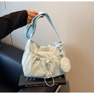 Detail of light blue pleated nylon shoulder bag with drawstring pocket and round coin purse