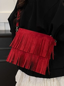 Sac bandoulière rouge bohème en daim avec franges porté par un mannequin