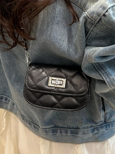 Mini quilted leather crossbody bag with silver twist lock and chain strap on denim outfit