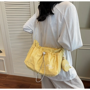 Yellow nylon drawstring tote bag detail with matching round coin purse on shoulder