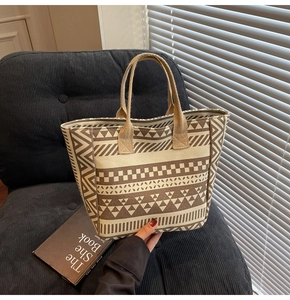Detail of geometric pattern canvas tote bag placed on a textured black sofa surface