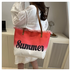 Detail of pink gradient canvas tote bag featuring Summer lettering and fringe trim