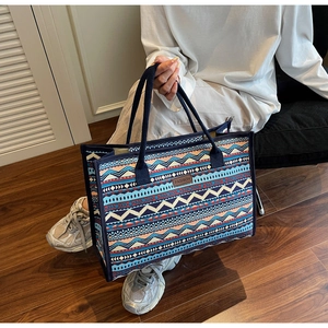 Detailed close-up of ethnic geometric canvas tote bag showing the brown FASHION leather tag