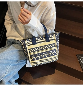 Detail view of woven canvas tote bag with geometric patterns on a lifestyle background