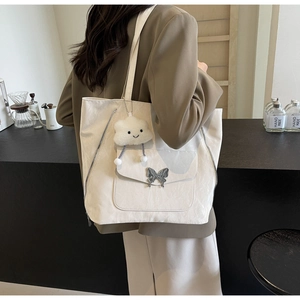 Detail of off-white tote bag with butterfly buckle and plush cloud charm
