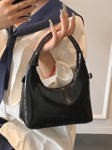 Glossy black patent leather hobo shoulder bag with a crescent shape and silver zipper