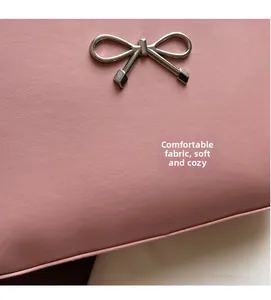 Close-up of pink lychee textured leather bag with a silver metal bow buckle detail