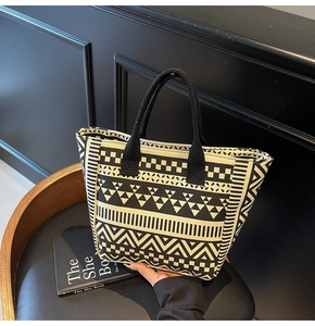 Detail of black and white geometric pattern and thick fabric straps on the canvas tote bag