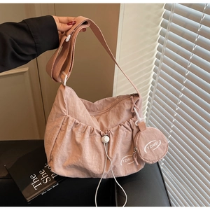 Detailed view of pink nylon crescent bag with drawstring texture and TZIMEI brand logo