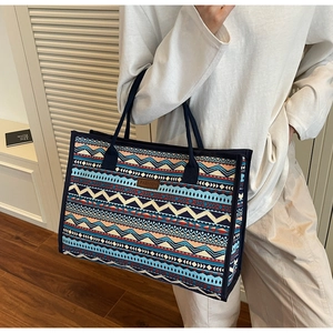 Detail of vintage ethnic canvas tote bag with geometric pattern and leather fashion patch