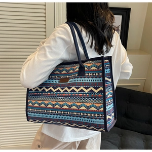 Detail view of ethnic canvas tote bag with geometric patterns and leather fashion tag