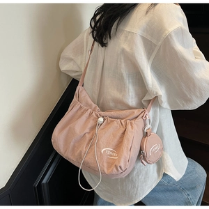 Detailed view of pink nylon drawstring crossbody bag with round zipper coin purse
