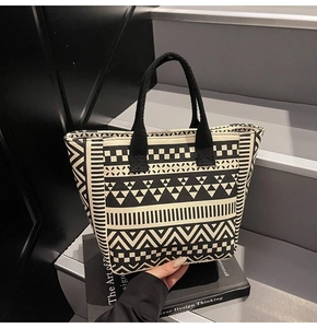 Detail of canvas tote bag with black and white geometric patterns on a staircase