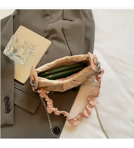 Detail of light pink pleated cloud bag showing spacious interior with green lining