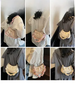 Detail view of ruched cloud bags with elegant pearl chains and metallic finish