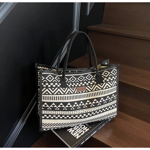 Detail of vintage geometric canvas tote bag showing fashion leather label and pattern