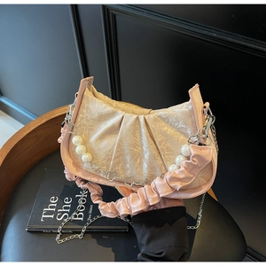 Detail of pink pleated cloud bag with pearl chain and delicate floral pattern fabric