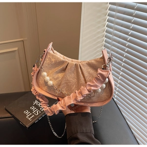 Detailed view of pink pleated cloud bag featuring premium jacquard texture and pearl chain