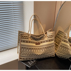 Detail of ethnic geometric pattern canvas tote bag with brown fashion leather label