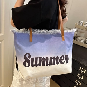 Blue canvas tote bag with leather handles and Summer embroidery on a model side view