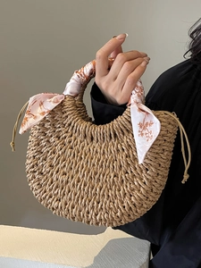 Handwoven straw half-moon handbag with decorative floral silk scarf and woven top handle