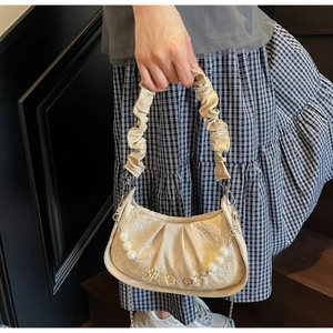 Detail of beige pleated cloud bag with pearl flower chain and ruched handle