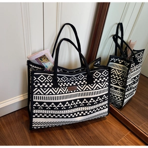 Macro detail of canvas tote featuring black and white ethnic geometric prints and leather patch