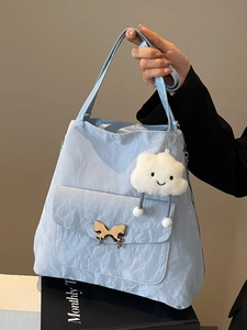 Light blue tote bag with crinkled texture, golden butterfly clasp and cloud charm